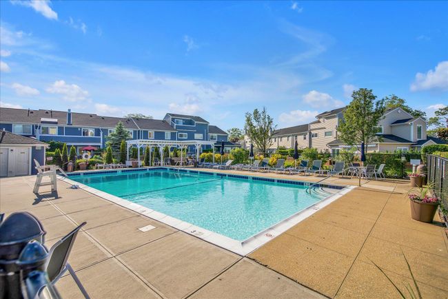 Community pool with a patio area, fence, and a residential view | Image 23