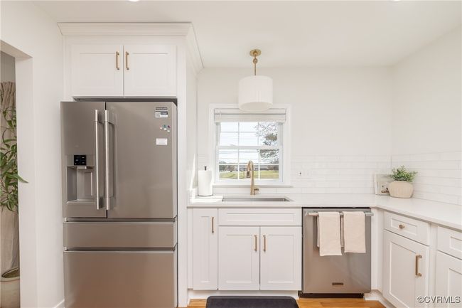 Kitchen featuring white cabinets, a sink, stainless steel appliances, and tasteful backsplash | Image 12