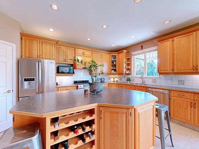 Kitchen featuring open shelves, appliances with stainless steel finishes, a kitchen island, recessed lighting, and dark countertops | Image 5