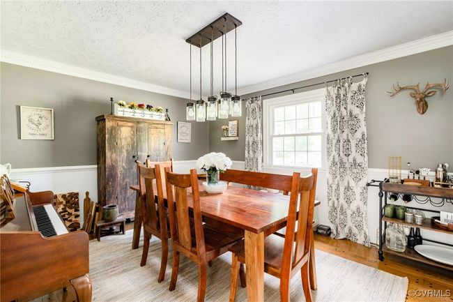 Multi member Crown Moulding, updated lighting and hardwood floors grace this beautiful dining room | Image 5
