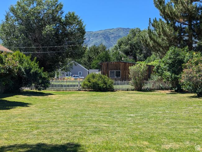 View of yard with a mountain view and fence | Image 41