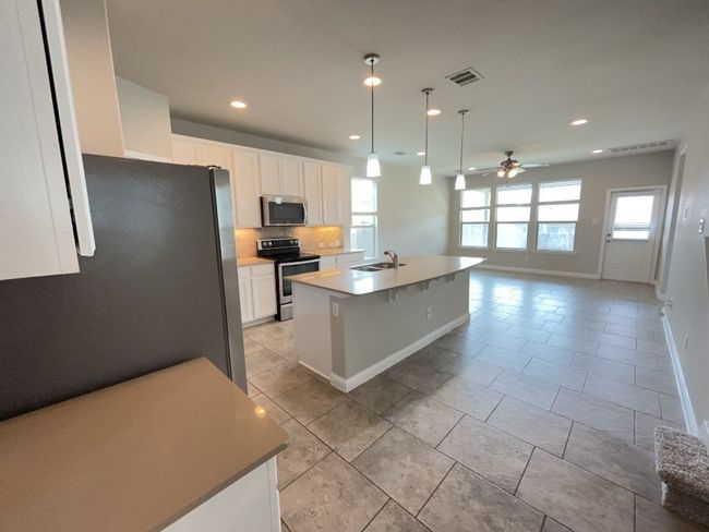 Kitchen featuring appliances with stainless steel finishes, plenty of natural light, recessed lighting, ceiling fan, and decorative backsplash | Image 6