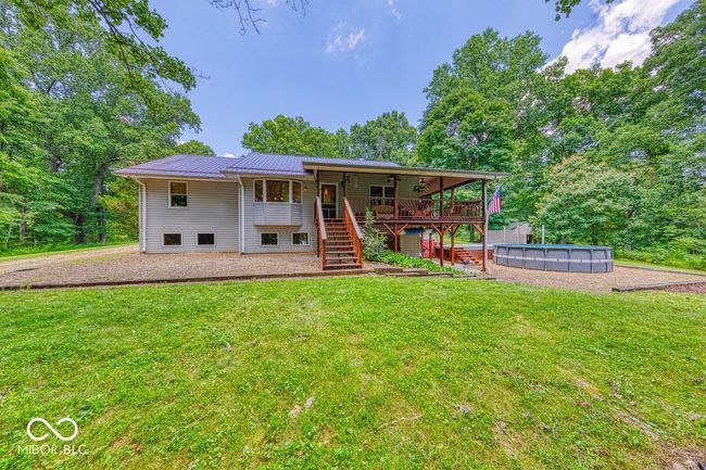 back of property featuring stairs, a yard, and a metal roof | Image 55
