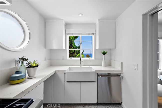 Kitchen with new farmhouse sink, quartz counters, and new cabinets. | Image 11