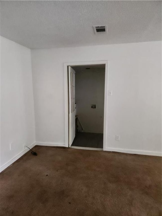 Spare room with dark colored carpet and a textured ceiling | Image 6