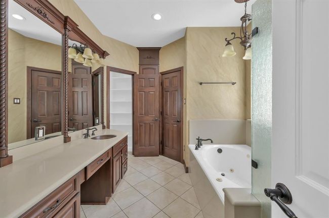 Primary Bathroom. Double Copper sinks with Vanity. Jetted Tub. Cabinet in the middle is a pass-through to the Laundry for Clean/dirty clothes and towels. | Image 23
