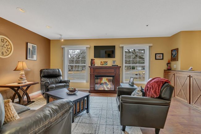 Large windows offer a bright and cheery feel to the upper level living room. Note the beautiful built in bookcase/cabinet with custom doors on the right. | Image 9
