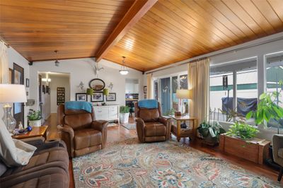 Living room with a wealth of natural light, hardwood / wood-style flooring, and lofted ceiling with beams | Image 2