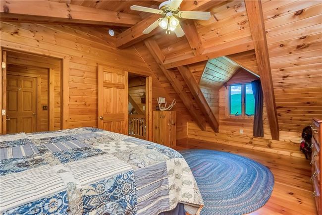 The upper-level full bathroom enhances convenience and comfort for residents and guests, providing a well-appointed space within the rustic charm of the log cabin. | Image 39