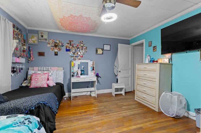 Bedroom featuring light wood-style flooring, crown molding, and ceiling fan | Image 29