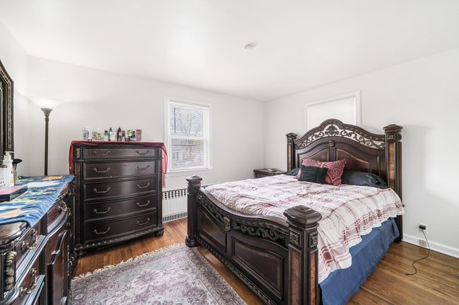 Bedroom featuring radiator and wood finished floors | Image 16