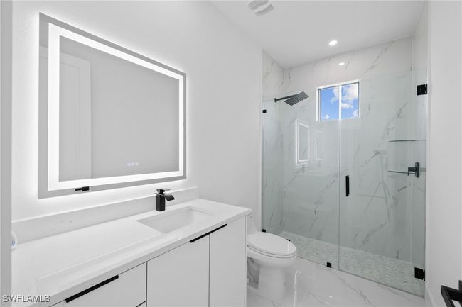 Bathroom with vanity, a marble finish shower, toilet, marble finish flooring, and recessed lighting | Image 17