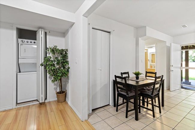 Dining area with light wood-style floors, visible vents, baseboards, and stacked washer and dryer | Image 25