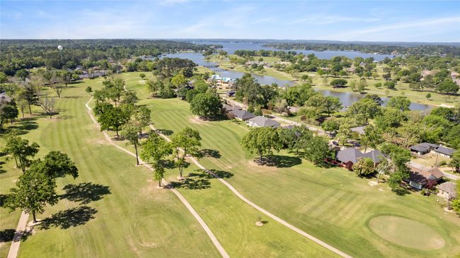 Aerial view of property's location featuring a nearby body of water, a local golf course, nearby suburban area, and a tree filled landscape | Image 24