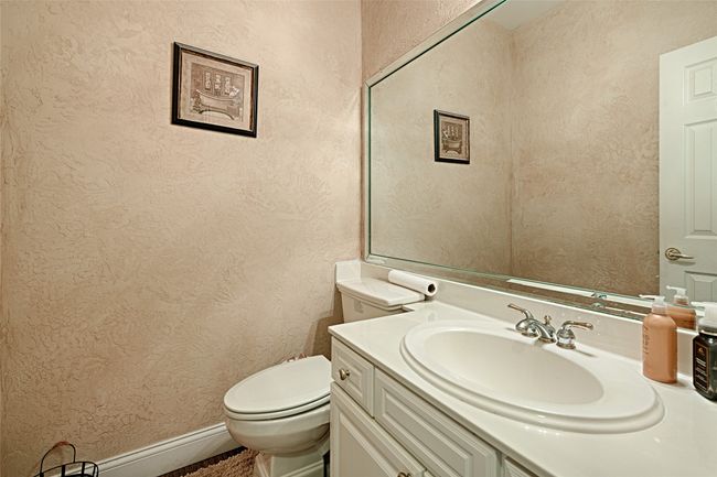 Bathroom featuring toilet, vanity, and a textured wall | Image 31