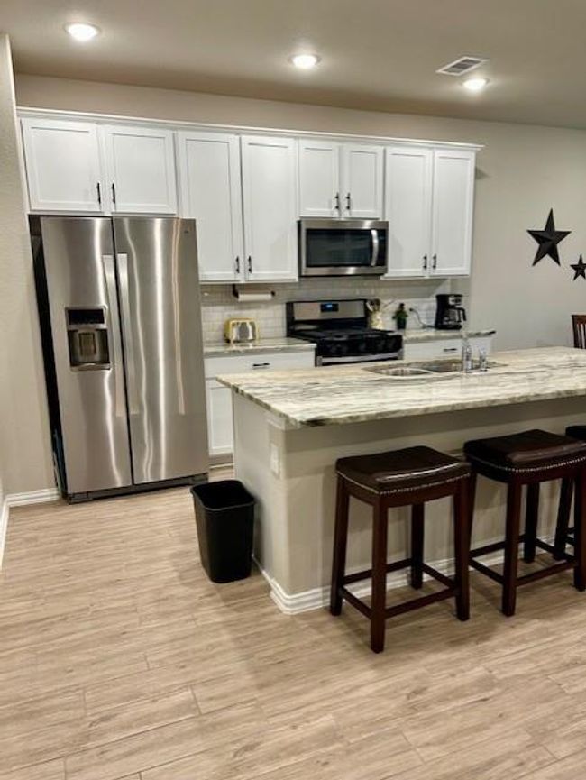 This kitchen has a breakfast area but also a bar where you can sit and critique those cooking and sample the food. | Image 7
