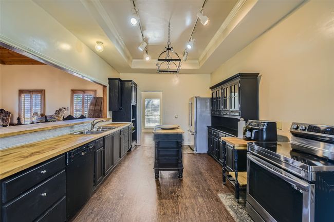 Entertain guests through the long serving bar (left) into the Den from your spacious kitchen. | Image 16