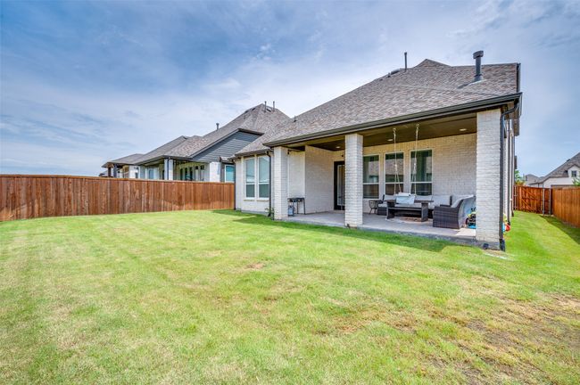 Rear view of house featuring brick siding, a fenced backyard, an outdoor living space, and a patio area | Image 20