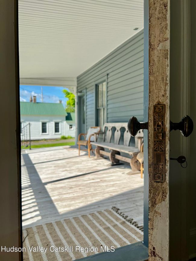 Deck off the living room with a door a foyer, then the kitchen. | Image 5