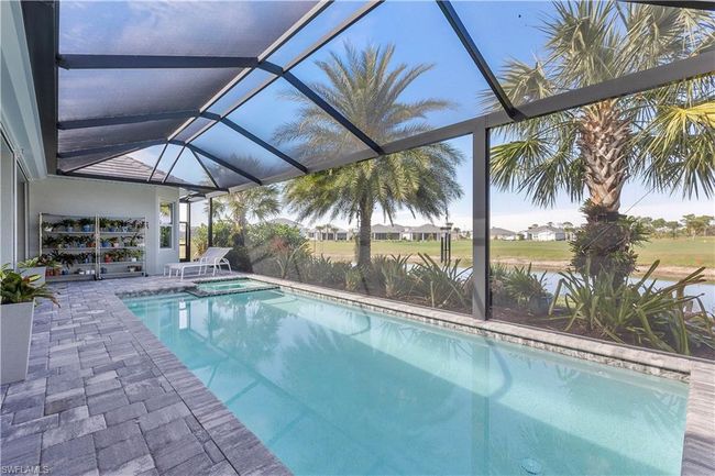 View of pool with a patio, a pool with connected hot tub, and a lanai | Image 25
