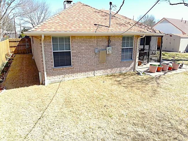 Back of house with fence, a storage shed, a patio area, and brick siding | Image 12
