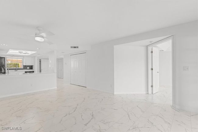 Unfurnished living room with a skylight, sink, light tile patterned floors, and ceiling fan | Image 4