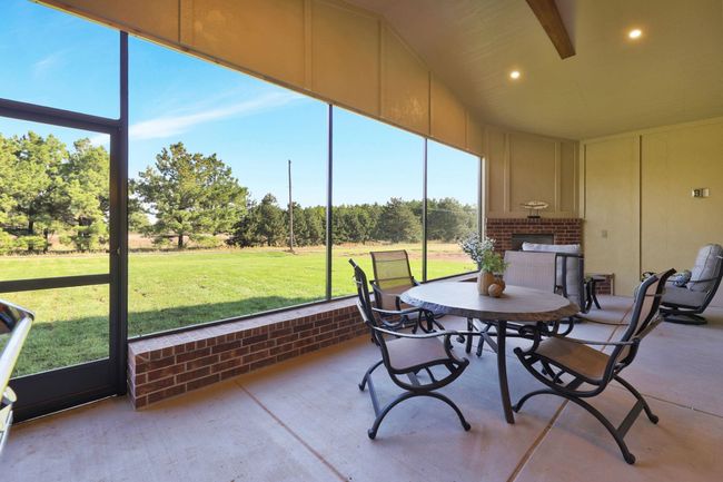 Sunroom featuring a brick fireplace | Image 34