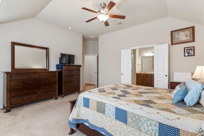 Primary bedroom has double doors leading to ensuite bath & ceiling fan. | Image 20