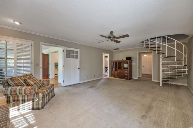 Unfurnished living room with carpet floors, a textured ceiling, crown molding, and ceiling fan | Image 20
