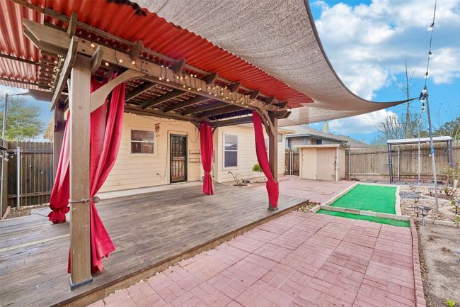 View of patio featuring a fenced backyard, a deck, a storage unit, and an outdoor structure | Image 20