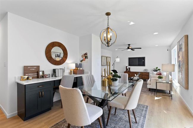 Dining area featuring light wood-type flooring and ceiling fan with notable chandelier | Image 10