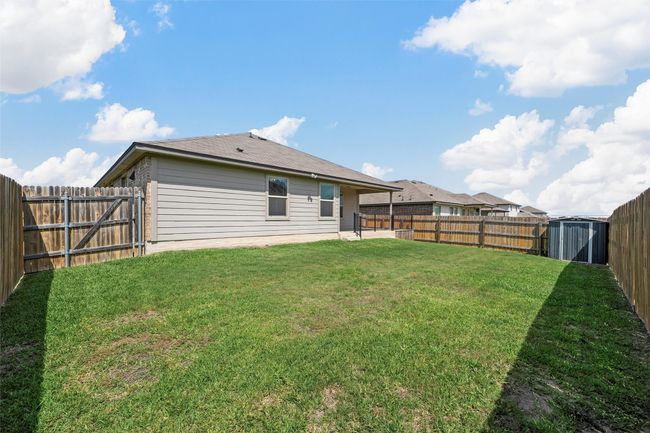 Back of house featuring a fenced backyard, a storage unit, and a patio | Image 30