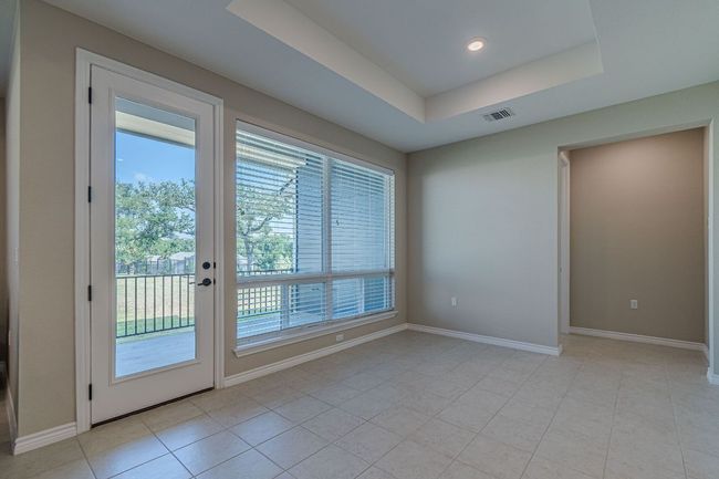 Spare room with a tray ceiling and light tile patterned floors | Image 17