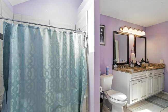 Full bathroom featuring vanity, curtained shower, and tile patterned flooring | Image 16