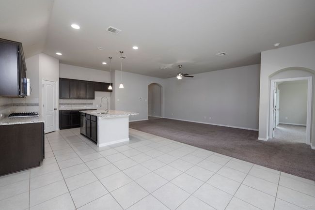 Kitchen featuring arched walkways, open floor plan, stainless steel appliances, recessed lighting, and a kitchen island with sink | Image 9