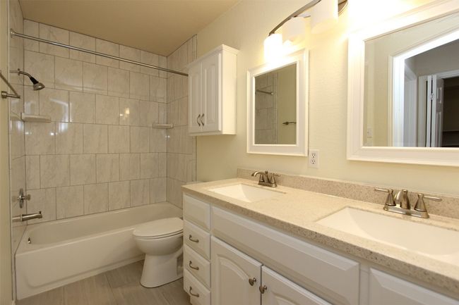 Full bath featuring double vanity and bathing tub / shower combination | Image 16