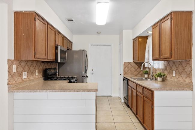 This kitchen features a fantastic layout with stainless steel appliances, making cooking and meal prep a breeze | Image 7