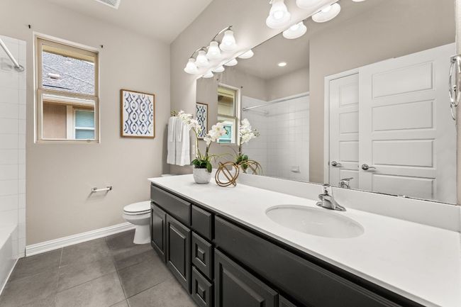 Bathroom with vanity, shower / tub combination, and tile patterned floors | Image 21