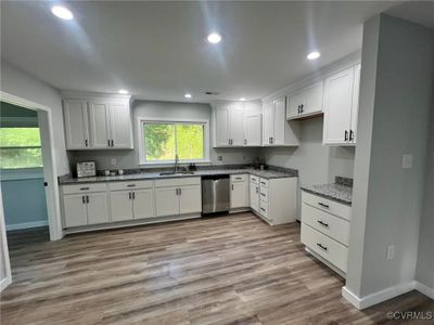 Kitchen with white cabinets, dishwasher, stone countertops, light hardwood / wood-style floors, and sink | Image 2