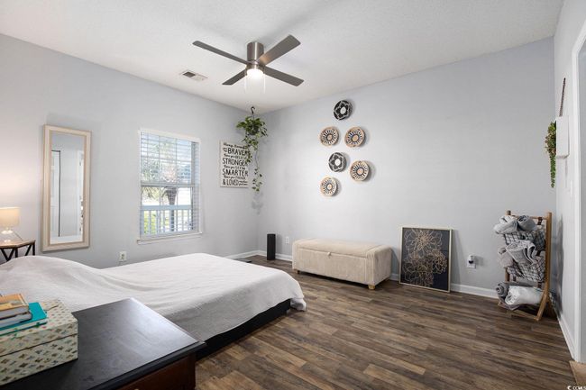 Bedroom with dark wood-style flooring, baseboards, and ceiling fan | Image 13