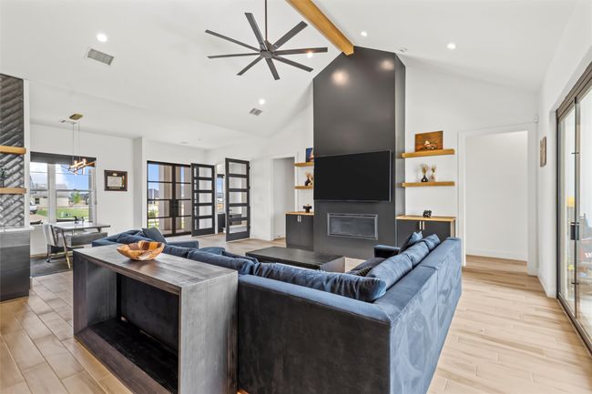Living room with visible vents, beamed ceiling, an inviting chandelier, and high vaulted ceiling | Image 9