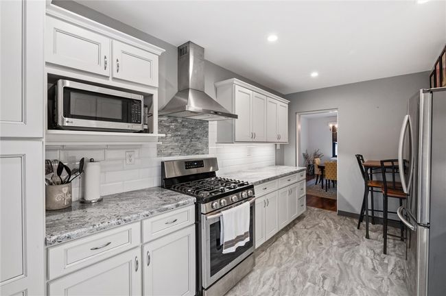 Recently updated, this kitchen features recessed lighting, stainless steel appliances and floor to ceiling pantry. | Image 4