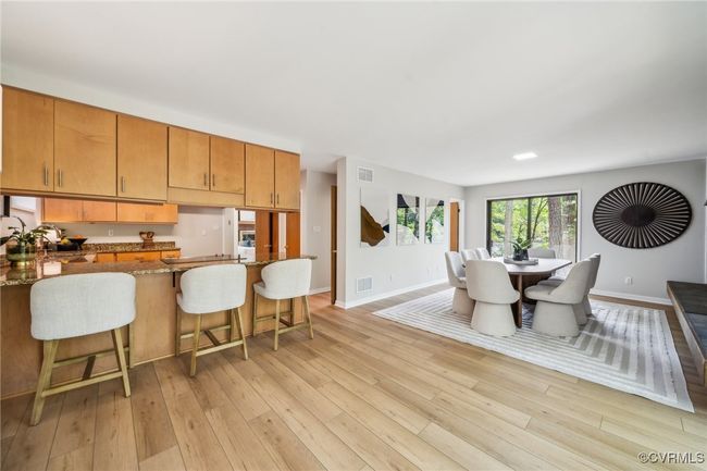 Dining space with light wood-type flooring, visible vents, and baseboards | Image 25