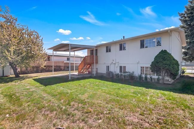 Rear view of house featuring a lawn, central AC unit, and fence | Image 25