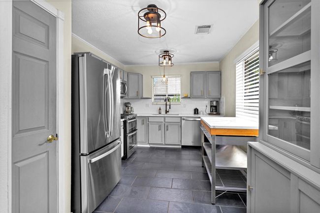 This well-appointed kitchen features sleek stainless steel appliances that combine style and functionality. Ample cabinet space is complemented by a pantry, providing room for storage and organization. | Image 11