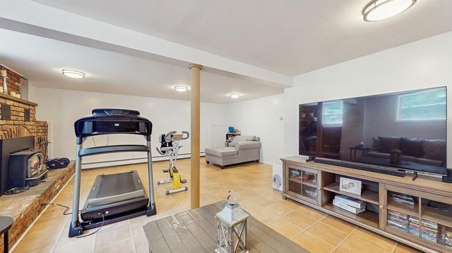 Workout area featuring ceramic tile patterned floors and a fireplace. | Image 30