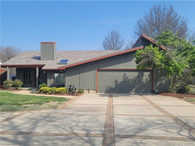 Mid-century inspired home with a chimney, a garage, and concrete driveway | Image 72