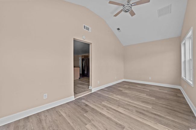 Unfurnished room with ceiling fan, lofted ceiling, and wood finished floors | Image 26