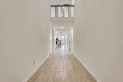 Hall featuring light hardwood / wood-style flooring and a towering ceiling | Image 3