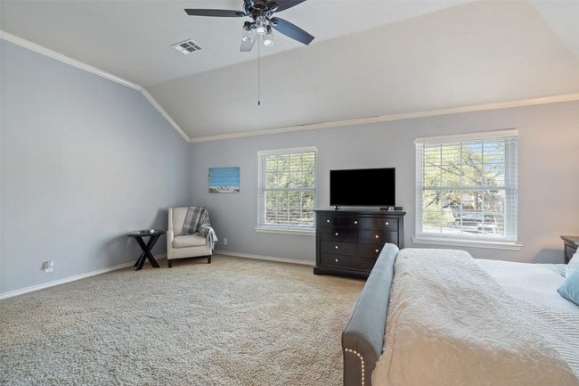 Bedroom featuring visible vents, crown molding, baseboards, carpet floors, and vaulted ceiling | Image 23